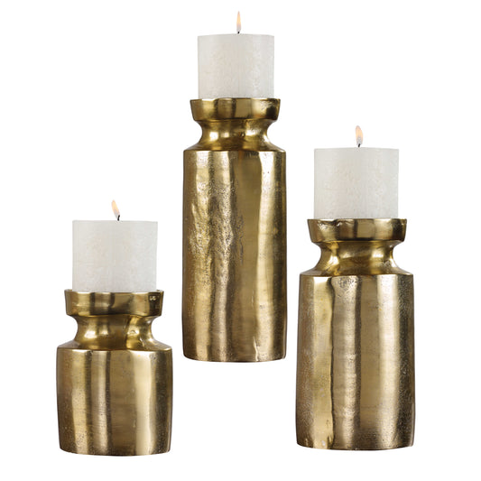 Set Of Three, Textured Cast Aluminum Candleholders Feature An Antiqued Brass Finish And Completed With Three 4"x 4" White Candles.