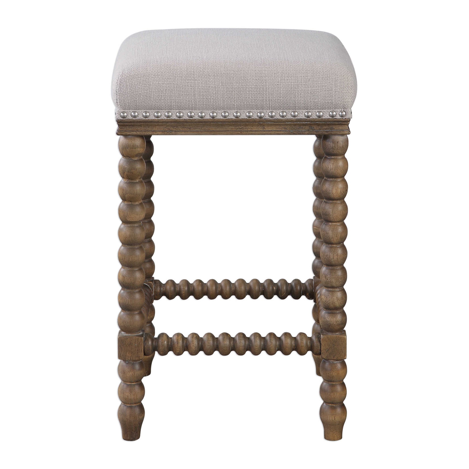 A Casual Statement Counter Stool Featuring Spindle Turned Legs And Carved Trim Finished In A Light Walnut Stain. Plush Seat Is Tailored In A Beige Linen Blend Fabric With Added Performance Treatment To Resist Soiling And Stains, Accented With Brushed Nickel Nail Head Trim.
