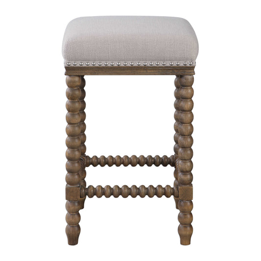 A Casual Statement Counter Stool Featuring Spindle Turned Legs And Carved Trim Finished In A Light Walnut Stain. Plush Seat Is Tailored In A Beige Linen Blend Fabric With Added Performance Treatment To Resist Soiling And Stains, Accented With Brushed Nickel Nail Head Trim.