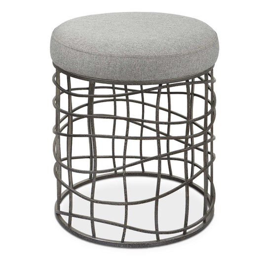 The Carnival Accent Stool Showcases A Fun Asymmetrical Iron Base Finished In Burnished Silver. The Round Seat Is Upholstered In A Casual Gray Polyester Fabric.
