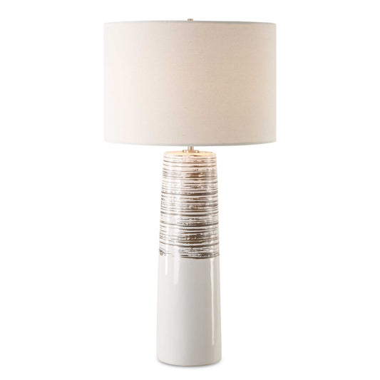 The Haven Table Lamp Combines Elegance With A Touch Of Rustic Charm. This Piece Features A Sleek Ceramic Base Cloaked In A Smooth White Glaze, Adorned With Subtly Ribbed, Distressed Accents, All Complemented By Brushed Plated Nickel Hardware For A Refined Finish.